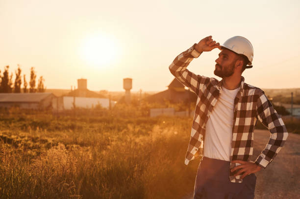 istock Touching the hard hat. Man is outdoors against sunset light. Rural scene 1663234997