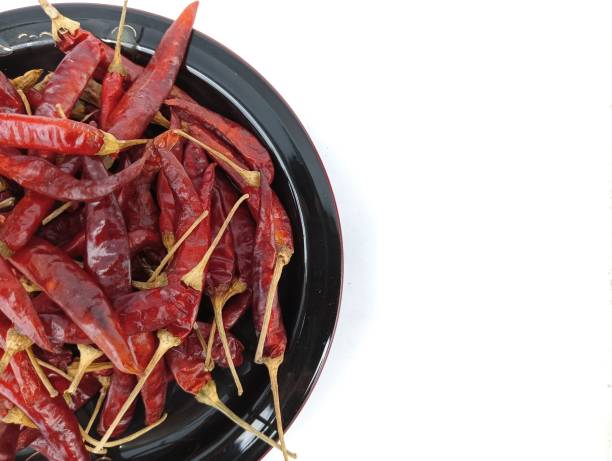 istock Dry chili peppers on a plate isolated on white background. 1663241608