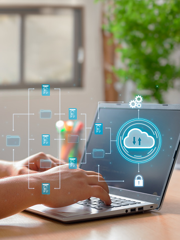 Vertical Photo of A man utilizes cloud computing technology on his laptop for data transmission, storage, backup, and retrieval