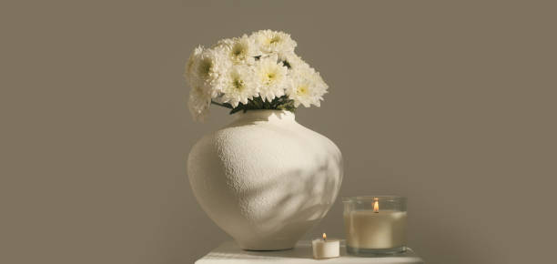 istock White chrysanthemums and burning candle in vase. 1663277052