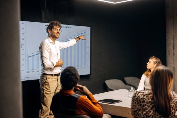 istock Young casually clothed businessman giving presentation to colleagues in conference room 1663291209