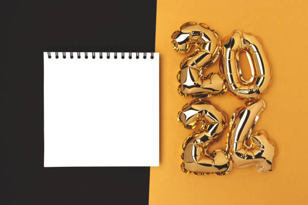 istock Empty notepad mockup and 2024 shiny air balloons on a gold and black background. 1663292839