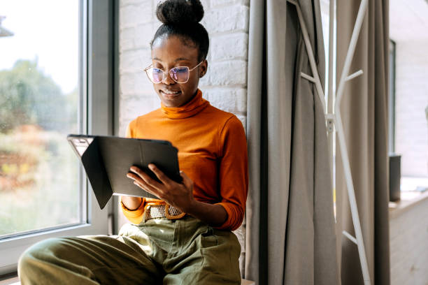 istock Young beautiful businesswoman using digital tablet while sitting by the window at modern office 1663295229