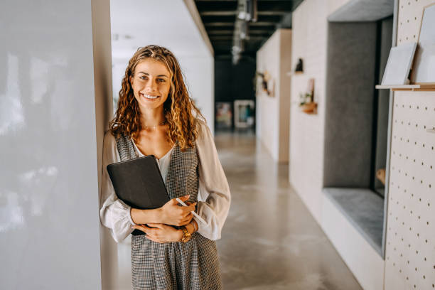 istock Portrait of young beautiful woman posing for a shot while holding digital tablet at modern office 1663297076