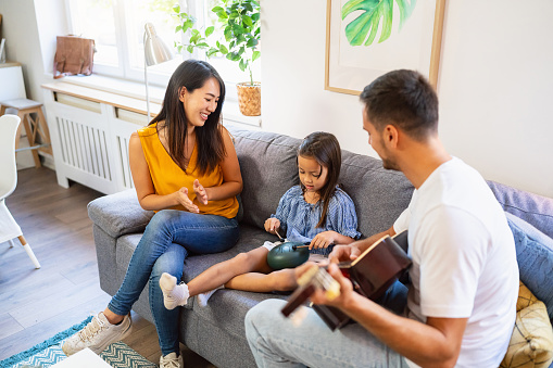 Multiracial Parents Teaching Their Daughter How To Play Tongue Drum multiracial-parents-teaching-their-daughter-how-to-play-tongue-drum