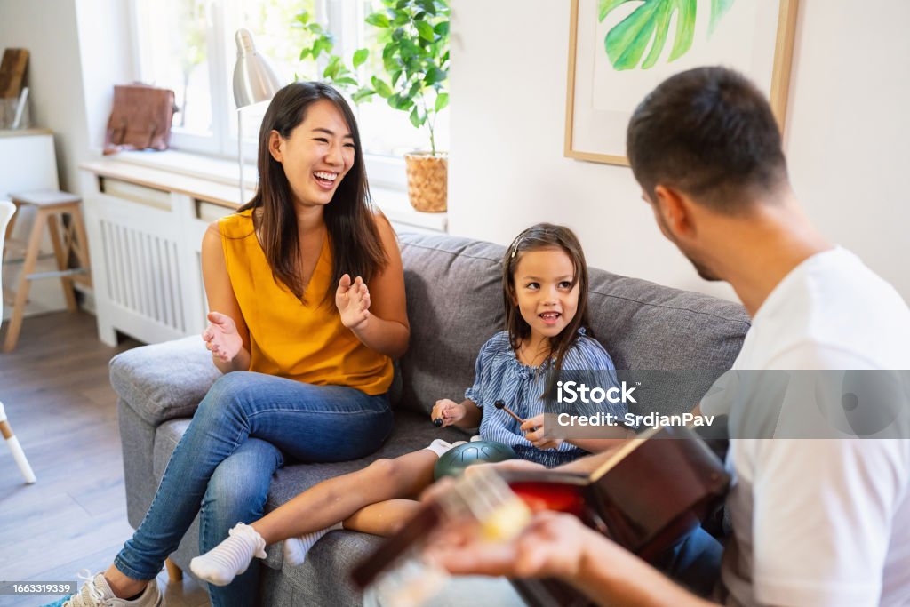 Multiracial Parents Teaching Their Daughter How To Play Tongue Drum multiracial-parents-teaching-their-daughter-how-to-play-tongue-drum