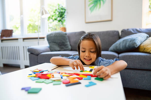istock Multiracial girl playing with multicolored puzzles at home 1663323711