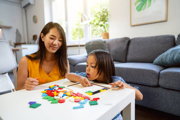 istock Mother and daughter Japanese ethnicity playing with multii-colored puzzles 1663325318