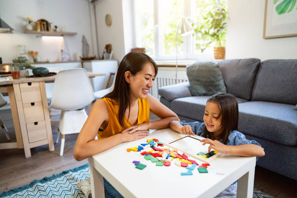 istock Mother and daughter Japanese ethnicity playing with multii-colored puzzles 1663326402