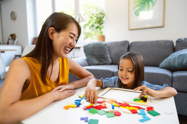 istock Mother and daughter Japanese ethnicity playing with multii-colored puzzles 1663326404