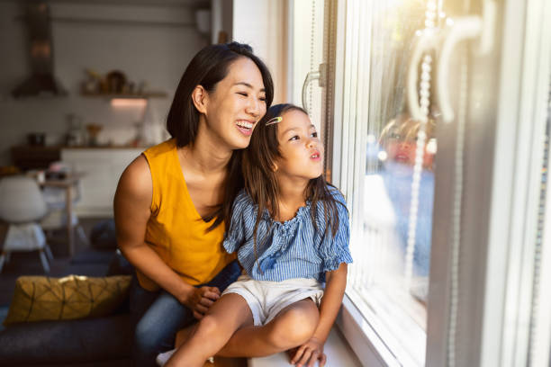 istock Mother and daughter Japanese ethnicity looking through window 1663340628