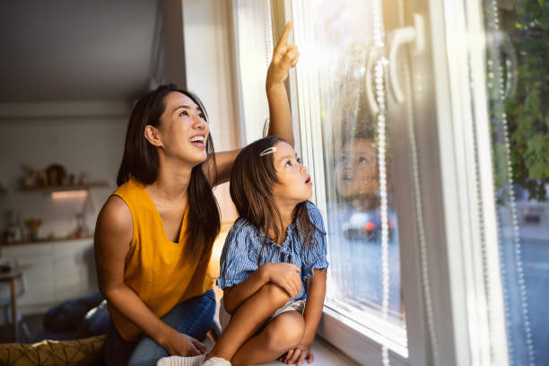 Mother and daughter Japanese ethnicity looking through window