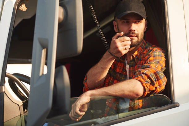istock Talking by using radio. Young truck driver in casual clothes 1663345540