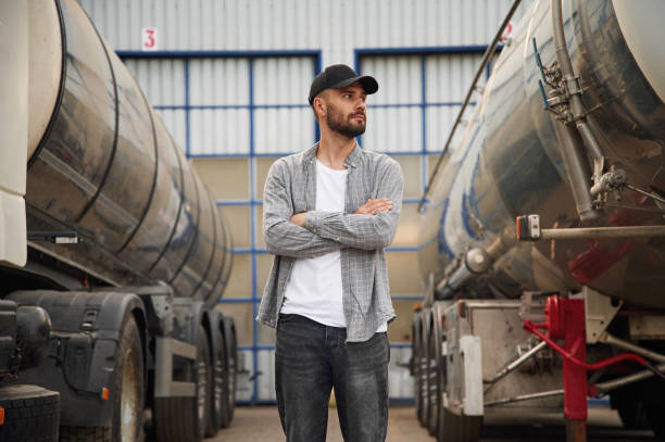 istock Between two vehicles. Young truck driver in casual clothes 1663348333