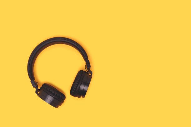 istock Black wireless headphones on a yellow background. 1663355859