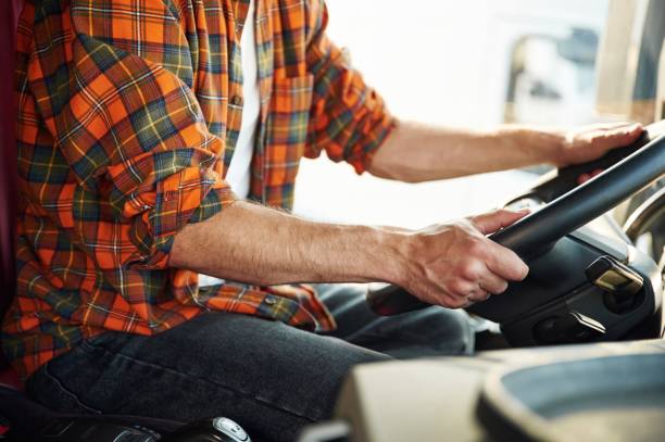 istock Close up view, sitting inside. Young truck driver in casual clothes 1663359706