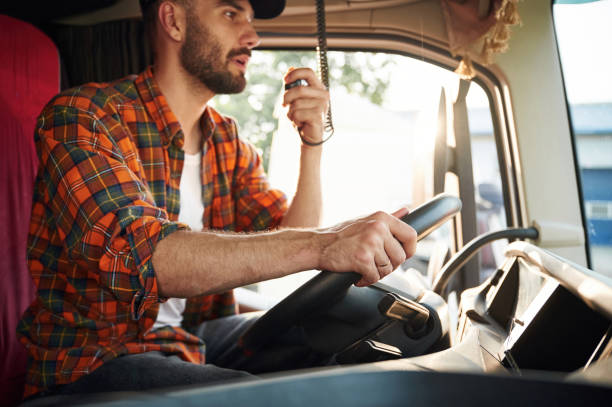 istock Talking by using radio. Young truck driver in casual clothes 1663360272