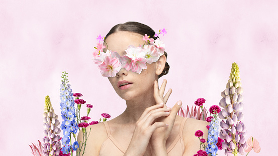 Banner. Poster. Contemporary art collage. Close up portrait of attractive girl with tender flowers elements over her face agains light pink background. concept of beauty, tenderness, flowers, blossom