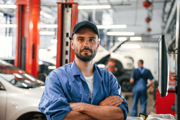 Standing with arms crossed. Auto mechanic working in garage. Repair service stock photo
