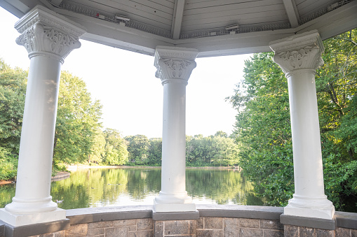 This is a photograph of architecture columns outdoors framing the lake at Piedmont Park in Atlanta, Georgia during summer.