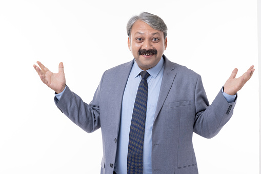 Young handsome businessman wearing suit standing over isolated white background clueless and confused expression with arms and hands raised.