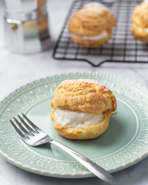 istock Choux cream, vanilla whipped cream stuffed cake on a green plate 1663389187