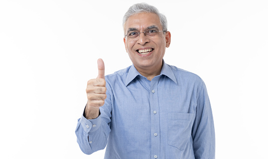 Portrait of smiling Indian couple showing thumbs up on white background