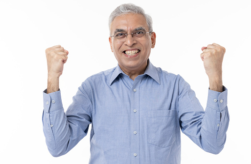Senior businessman holds arms up in celebration