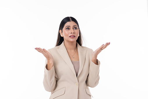 Happy young woman gesturing an open hand against white background.