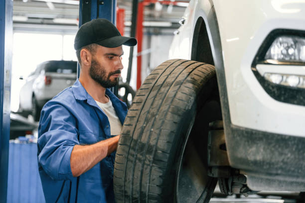 istock Setting up new wheel. Auto mechanic working in garage. Repair service 1663393067