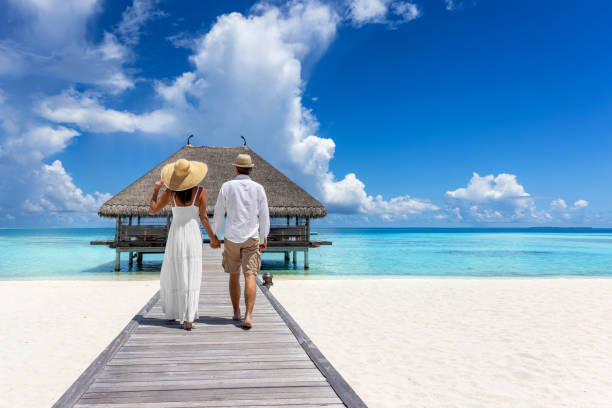 istock A luxury couple in summer clothing walks hugging over a pier at a tropical beach 1663409002