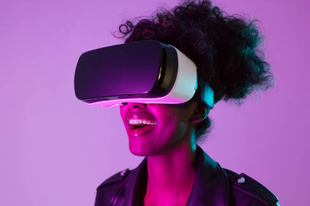 istock Beautiful woman wearing VR glasses in pink neon light 1663442894