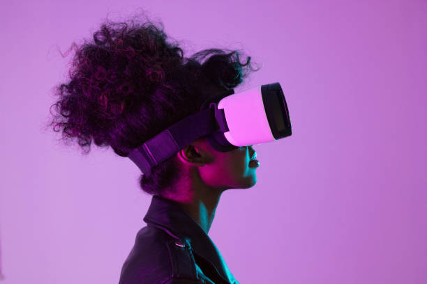 istock Beautiful woman wearing VR glasses in pink neon light 1663446796