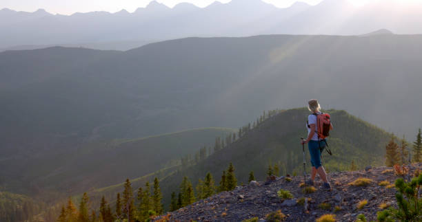 istock Mature female hiker pauses on mountain slope 1663457641