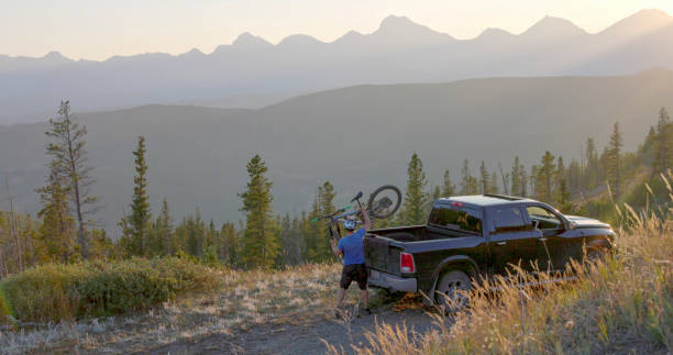 istock Mountain biker arrives at vehicle on mountain road 1663458795