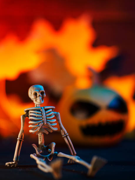 istock Creative concept halloween card. Skeleton, orange pumpkin and autumn yellow leaves. copy space 1663507850