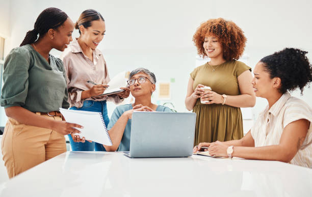 istock Laptop, document and women in office in discussion for teamwork brainstorming with manager. Diversity, planning and professional people with computer and paperwork for creative project in workplace. 1663526909