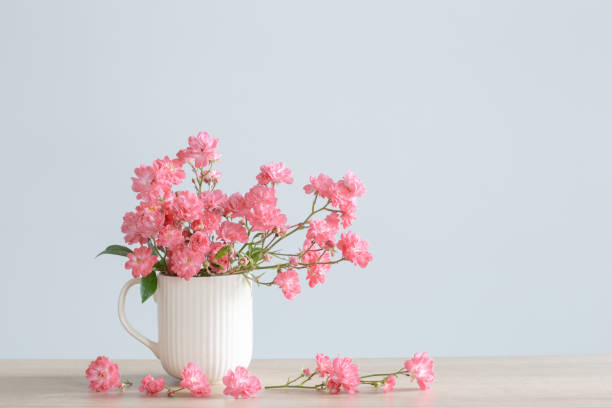 Dried roses and a cup of rose tea on wooden