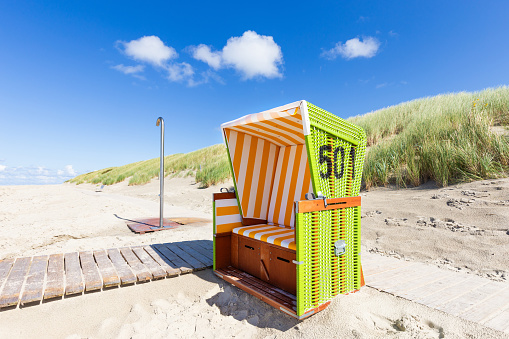 A closeup shot of a blue beach chairs in a sandy beach