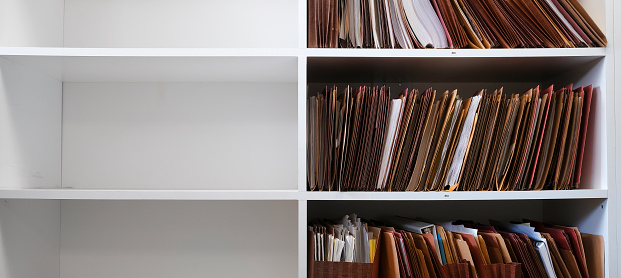 Files organized on an office shelf for clients papers and information