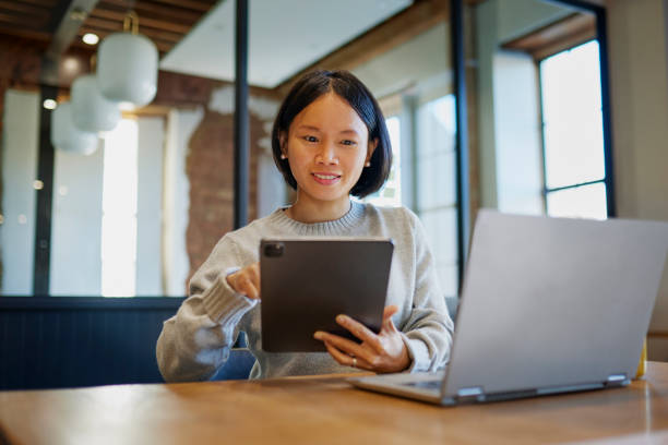 istock Smiling businesswoman using digital devices on office desk 1663562930