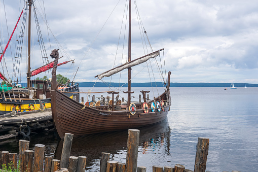 Petrozavodsk, Russia - July 30 2023: modern replicas of old sailing ships are moored on the pier near the shore of Lake Onega