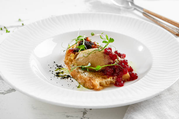 istock Chicken liver pate on crispy bread with red currant jam and micro green. Bruschetta with chicken pate in white plate. Delicious appetizer - foie gras on toast. Liver pate with jam in rustic style. 1663570767