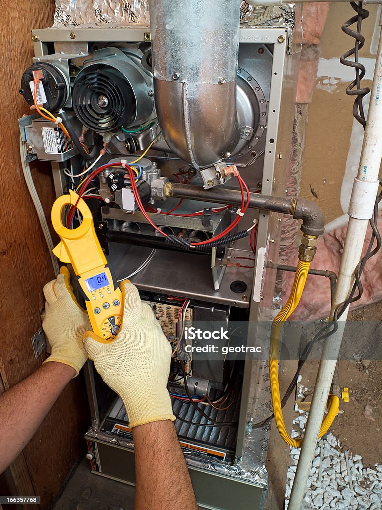 Hispanic air conditioning repair man fixing system Hispanic airconditioning repair man performing maintenance Furnace Stock Photo