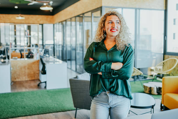 istock Smiling businesswoman with arms crossed, looking sideways in breakout space 1663605443