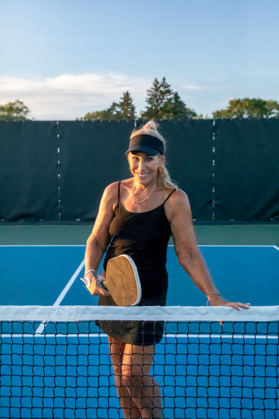 istock Female Pickleball Player Posing At Net 1663615340