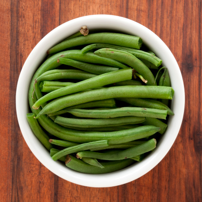 Top view of white bowl full of green beans