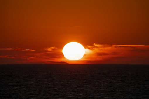 Big sun at sunset in the sea on the horizon. High quality photo