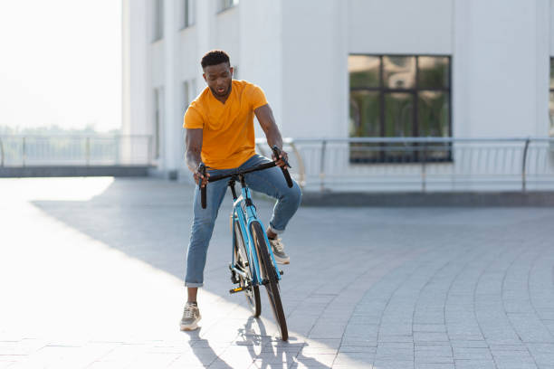 Full length view of positive African American man preparing riding bicycle