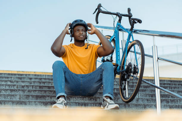 Happy multiracial man wearing protective helmet sitting at the stairs